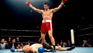 A victorious boxer stands over a defeated opponent in a packed arena, symbolizing an organization overcoming waste, chaos, and stress through the power of operations science.