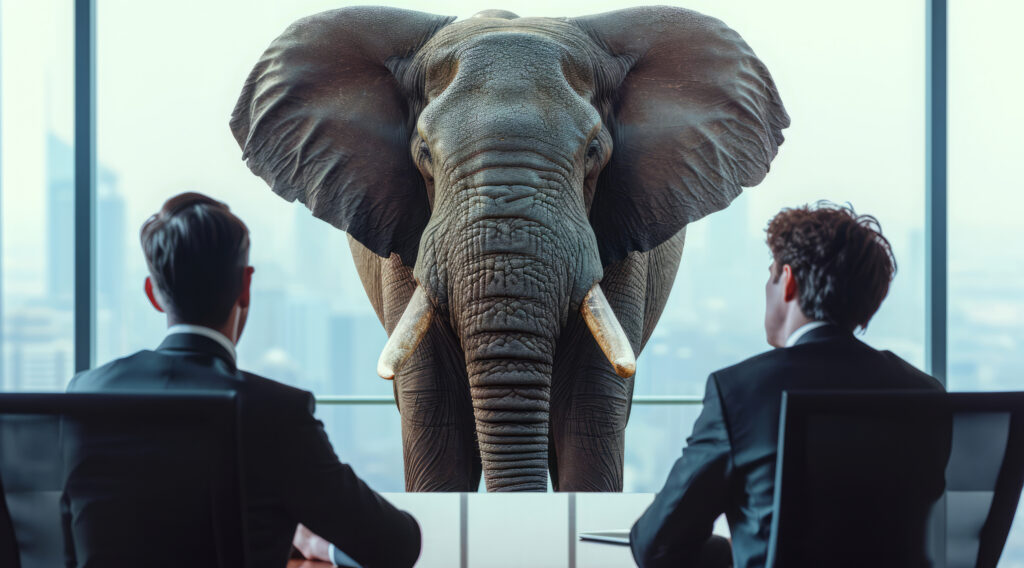 Two business leaders in suits sit at a conference table staring at an elephant representing operations performance but they can't understand it without operations science